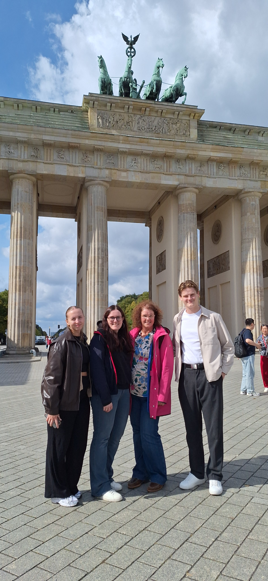 Vier Teilnehmende vor dem Brandenburger Tor in Berlin.