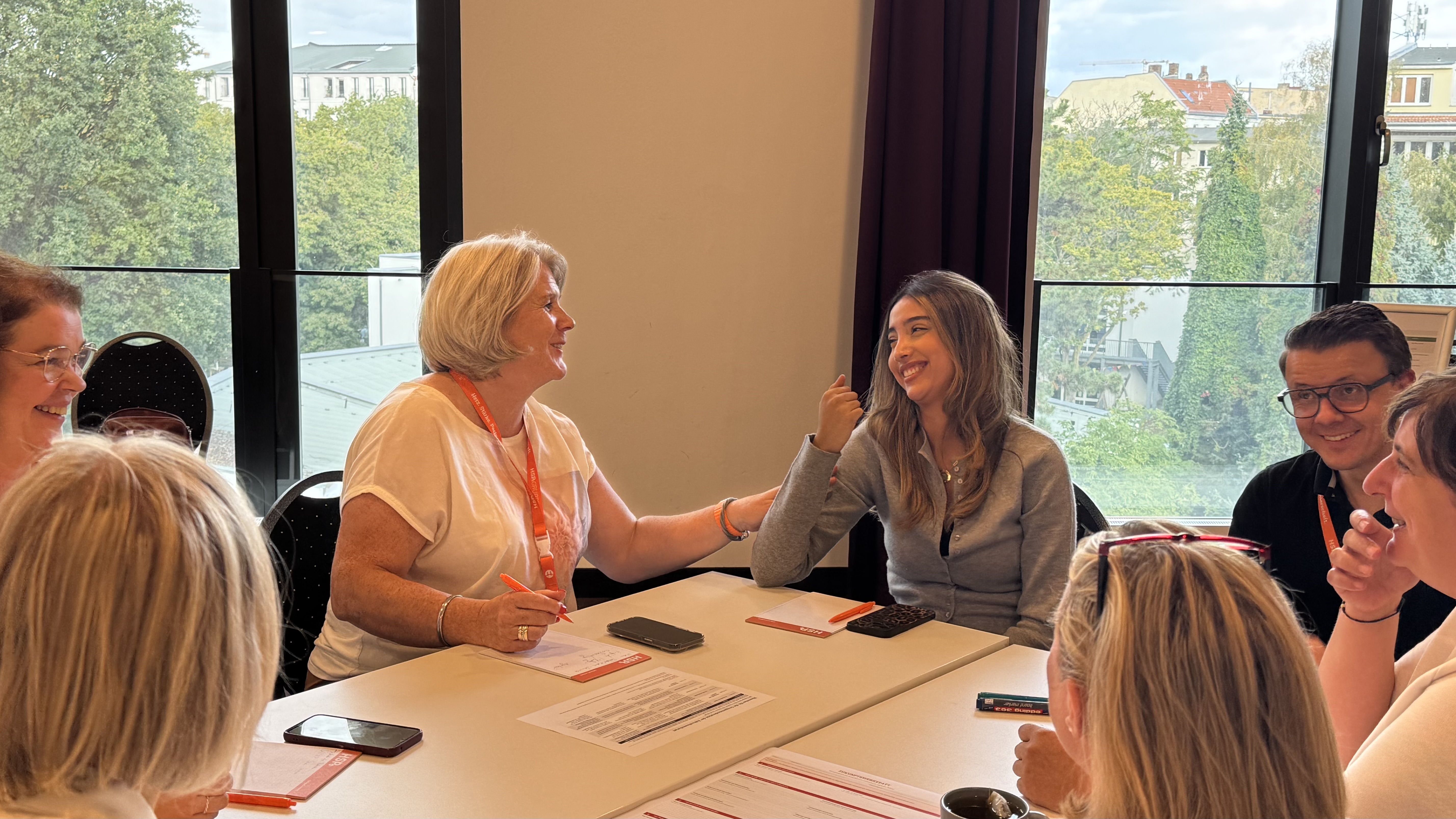 Teilnehmende lachen und diskutieren bei der gemeinsamen Gruppenarbeit.